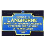 A photo of the Langhorne Borough sign stands proudly, denoting the community served by Leck Waste. The sign features a white background with bold black lettering that reads "Langhorne Borough." It is mounted on a sturdy metal post, surrounded by greenery. The sign serves as a symbol of the company's commitment to providing waste management services to the residents of Langhorne Borough.